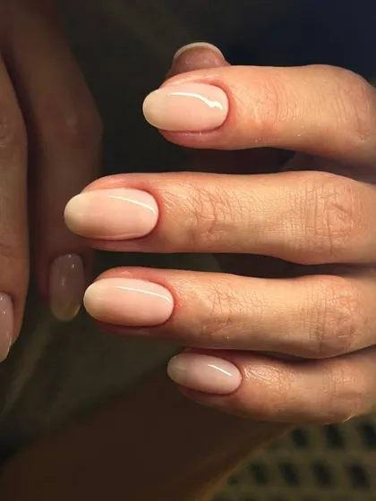 A sheer, natural-looking nude overlay on oval nails. This service is perfect for adding strength and a polished look to your natural nails.