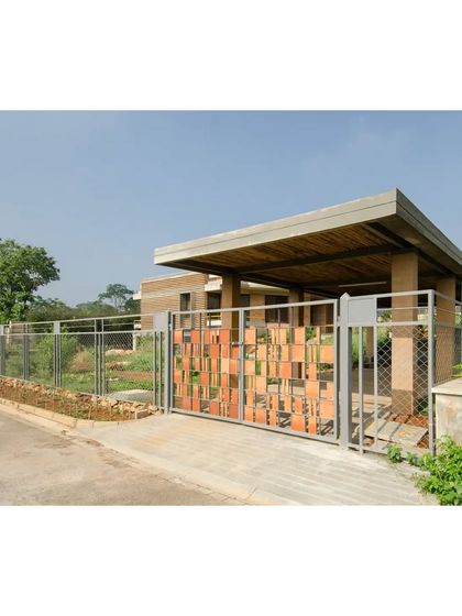 The entrance gate featured in a publication, noted for its use of simple, honest materials that reflect the overall philosophy of the house. It's a prelude to the earthy and sustainable design within.