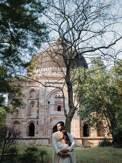 A quiet moment for a couple against the backdrop of ancient tombs and lush greenery at Hauz Khas, Delhi, blending old-world romance with nature.