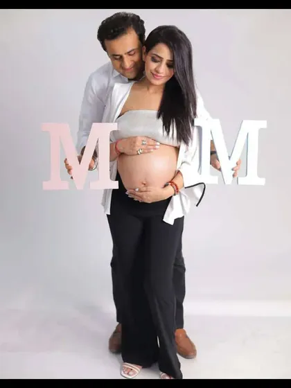 Announcing your new role with pride. This couple chose to use "MOM" letters to celebrate the transformation into motherhood, creating a sweet and modern maternity announcement photo.