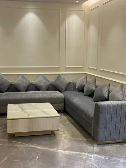 A direct view of the grey sectional sofa, showcasing its generous proportions and plush cushions. We design our sectionals to be the heart of the living room, perfect for family gatherings and relaxation.