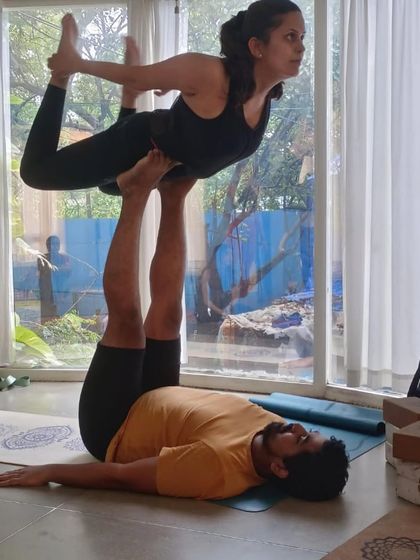 An Acro Yoga backbend pose, 'Bow on Throne'. This is a beautiful partner stretch that helps open the flyer's heart and spine with the support of the base.
