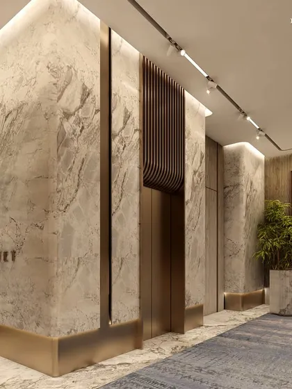 The corridor leading to the banquet hall at Ceejay Residency. The walls are clad in dramatic marble with brass inlays, setting a tone of opulence and elegance for the exclusive clubhouse experience.