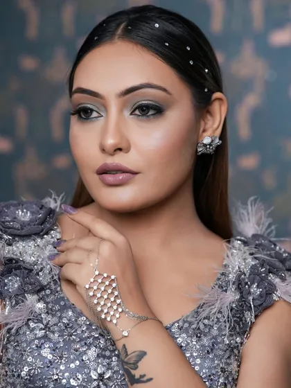 The side profile shows off the sleek hair with crystal embellishments and the sharp contour. This look is all about high-fashion glam for your special events.