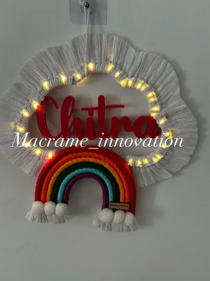 Another view of the 'Chitra' name hanging with the lights on, creating a cozy and magical effect.