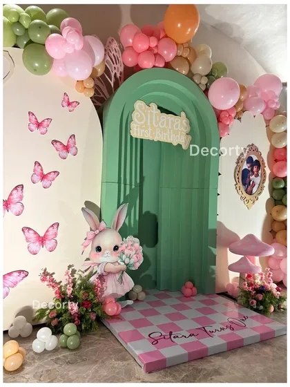 A close-up of the Wonderland backdrop, showing the checkered floor, bunny prop, and butterfly details.