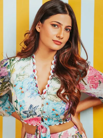 A close-up beauty shot that complements the floral outfit. The focus is on the model's fresh, natural makeup.