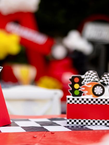 Close-up of the table decorations for the Ferrari party, including miniature checkered flags and themed party hats.