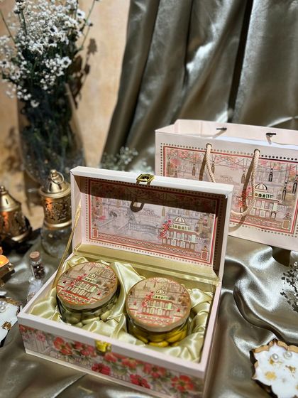A closer look at the haveli-themed box, opened to show the two jars of goodies inside. The intricate artwork on the inside of the lid is a special touch.