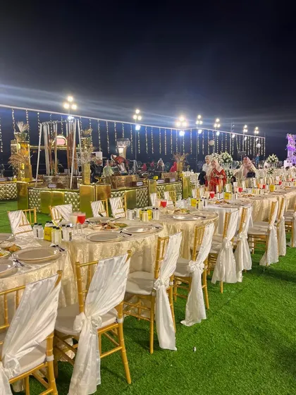 The elegant dining setup with white-draped chairs and beautifully laid tables, ready for a memorable meal.