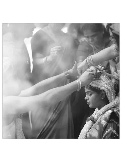 A powerful black and white photo of a sacred wedding ritual. The smoke and focused expressions create a dramatic and spiritual atmosphere.