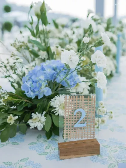 For a ceremony in the mountains, we used a palette of soft blues and whites, with natural cane details on the table numbers to complement the setting.