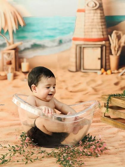 A candid giggle during a fun, beach themed baby photoshoot. These sessions are all about capturing genuine moments of play and happiness.