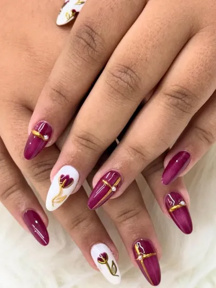 Wine red with a bloom of gold. This chic and understated set features deep burgundy nails with white accent nails showcasing a single, elegant hand-painted tulip.