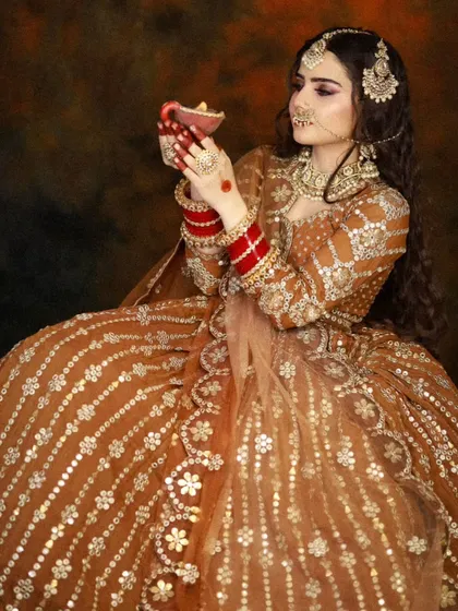 A bride holding a traditional diya. This shot captures a serene and spiritual moment, with makeup that looks beautiful in the warm, soft light.
