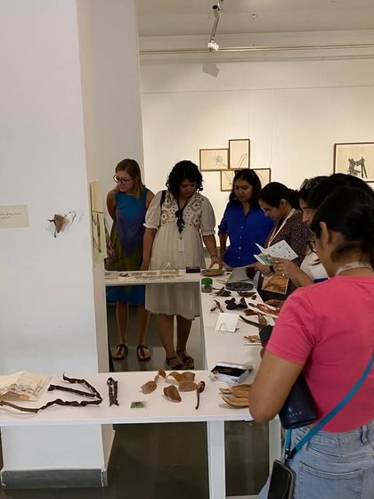The MAP team closely examining the intricate objects and drawings displayed on the tables.