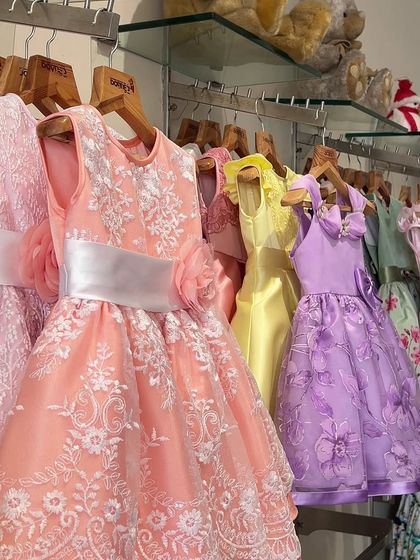 A rack of my colorful party dresses, showcasing a rainbow of options from peach lace to lavender floral.