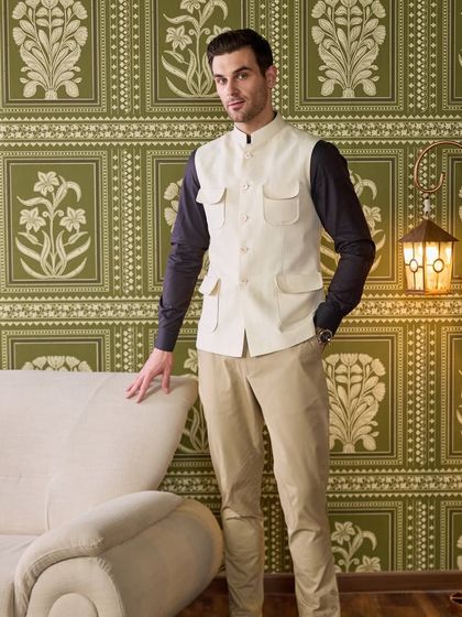 Smooth on the skin, sharper on the outside. This four-pocket waistcoat in a neutral shade effortlessly enhances your summer evening look with a touch of utilitarian chic.
