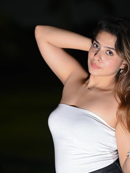 A striking close-up portrait shot at night. The flash isolates the model against the dark background, creating a dramatic and intimate feel.