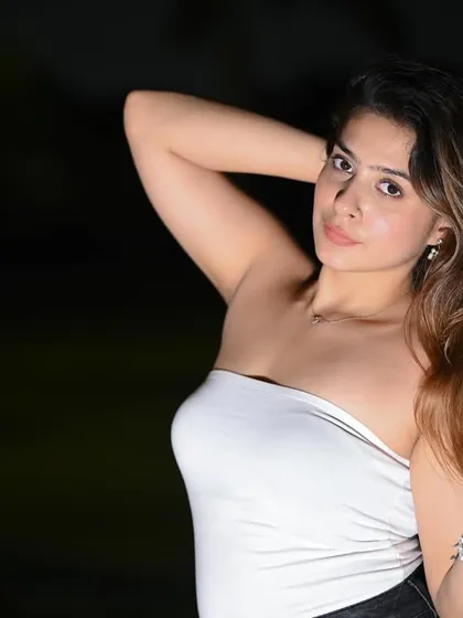 A striking close-up portrait shot at night. The flash isolates the model against the dark background, creating a dramatic and intimate feel.