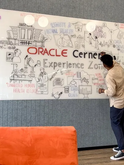 Here's a shot of me working on a large glass mural for the Oracle Cerner Experience Zone. The goal was to visualize the future of health-tech, illustrating concepts like data-driven health and secure cloud architecture through my doodle art style.