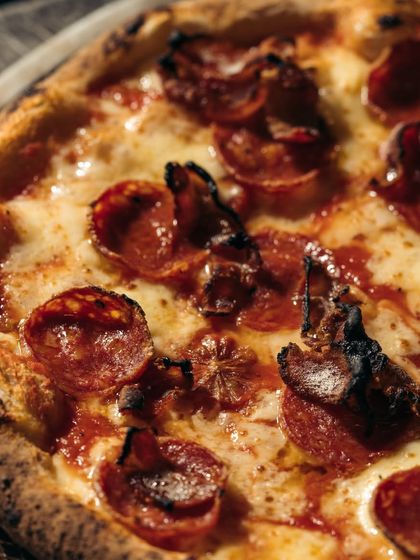 A close-up on this pepperoni and bacon pizza shows how the edges of the meat get crispy and curl up in the high heat of the oven, adding incredible texture and flavor.