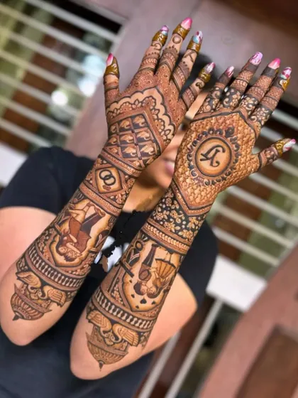 This design shows the back of the hands, featuring a large initial "R" and wedding rings, surrounded by traditional patterns.