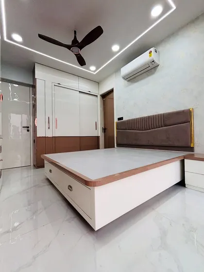 A wide-angle view of the finished bedroom, highlighting the spacious feel achieved through smart furniture placement and a light color palette.