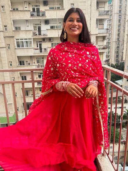 A happy, candid shot in my festive pink suit. My job is to help you find outfits that not only look good but also make you feel joyful and ready to celebrate.