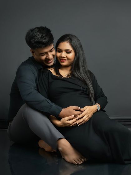 The same pose in color, highlighting the warmth and intimacy of the moment. The dark, simple outfits keep the focus on their expressions and connection.