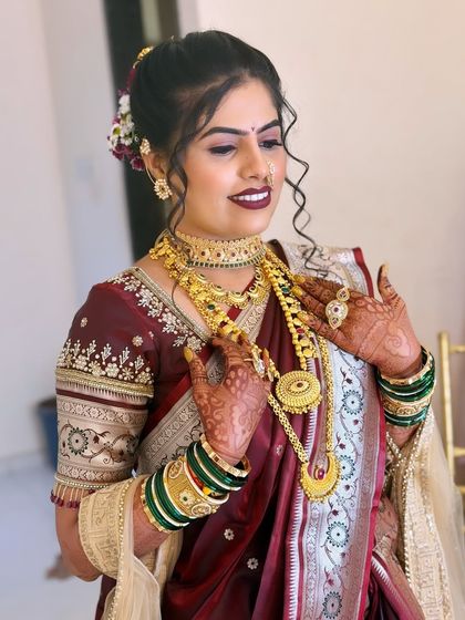 The bride admiring her heavy gold necklace. I ensure the makeup complements the jewellery, rather than competing with it.