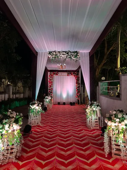 Looking down the elegant reception walkway, with its floral-adorned wooden crates and dramatic lighting.