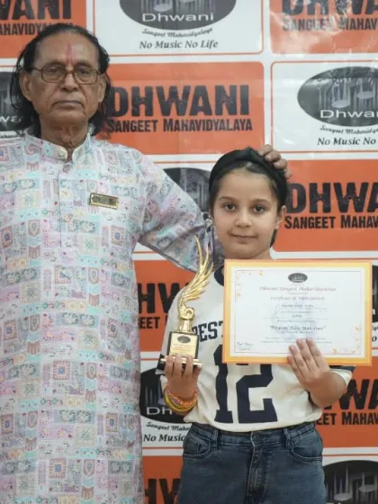 A senior guru with a young student and her award.