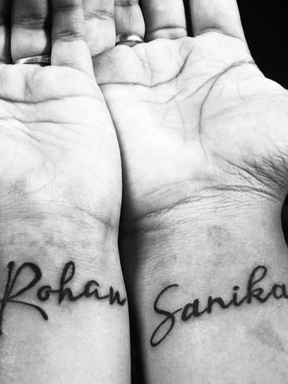 A couple's tattoo with the names "Rohan" and "Sanika" on their respective wrists. A simple and beautiful way to show commitment.