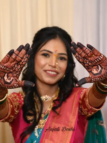 A happy bride showcasing the beautiful, dark stain on both her hands, a result of natural henna and good aftercare.
