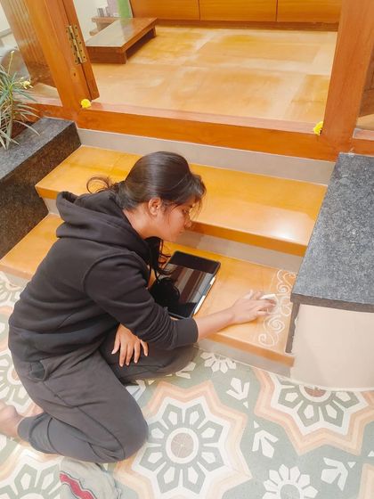 Using a reference on my tablet, I ensure the traditional patterns are accurately translated onto the steps. Each swirl and line is placed with intention.