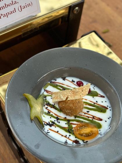 A beautifully plated Dahi Bhalla, where we focus on the art of plating even for classic dishes. The artistic drizzles and starfruit garnish elevate this simple dish into a work of art.