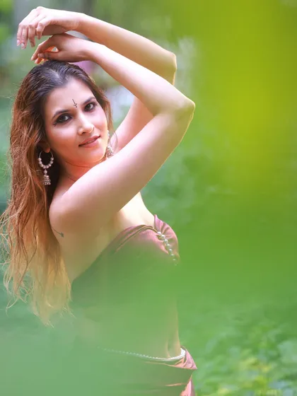 An outdoor portrait where I used the natural foliage to frame the model. This technique adds depth and a sense of mystery to the shot, focusing on her expression.