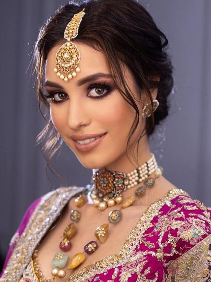 A smiling portrait of the regal bride, showing that even a dramatic makeup look can feel light and comfortable.