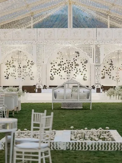 A wide view of the entire sangeet setup, showcasing the grand stage, elegant seating, and magical lighting. This is event design on a spectacular scale.