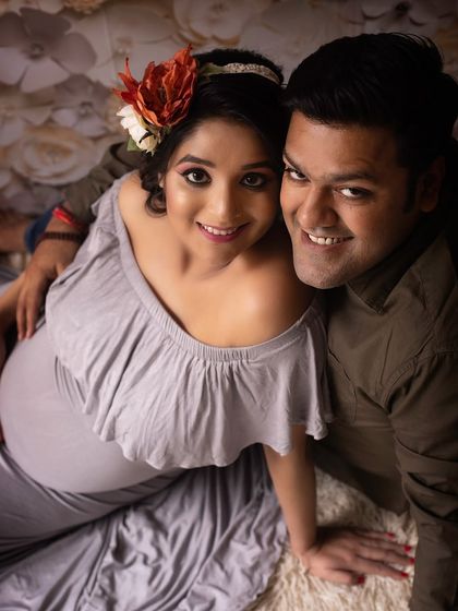 A beautiful portrait of an expecting couple. The way they are looking at the camera together shows their shared joy and excitement.