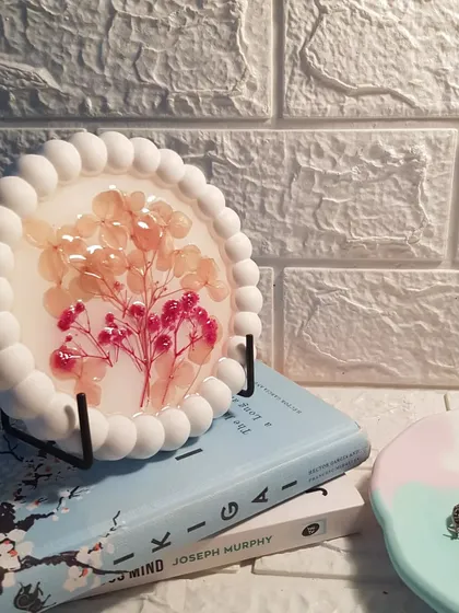 The floral resin bubble tray displayed on a stand. It's a unique piece of art that combines two different materials and techniques.