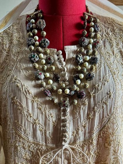 A close-up of the neckline, showing how the heavy embroidery of the Anarkali pairs with traditional jewelry.