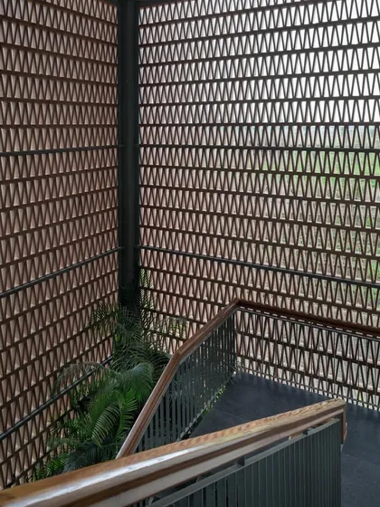 This project by Dhananjay Shinde Design Studio features a prominent terracotta jali screen that provides privacy and ventilation while creating intricate light patterns.