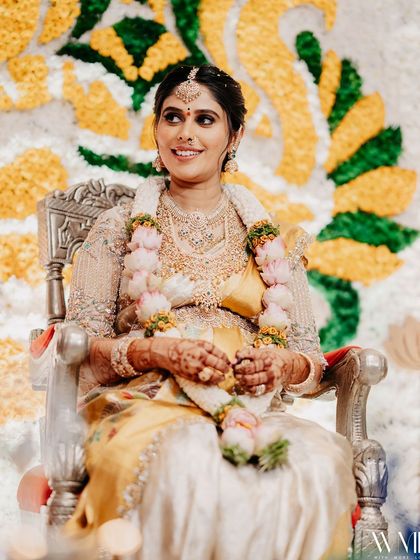 A beautiful portrait of me seated at my baby shower, looking radiant in my custom-designed saree.