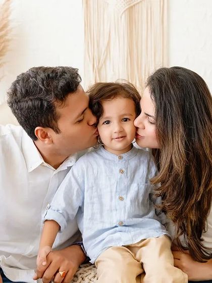 A sweet family moment with parents kissing their son's cheeks. I encourage these affectionate interactions to capture genuine love during our studio sessions.
