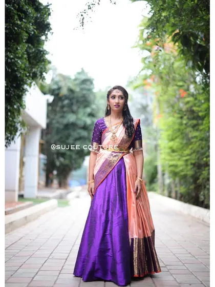 This is a complete South Indian half saree, or langa voni, that I designed. The rich purple silk skirt contrasts beautifully with the peach and gold dupatta, creating a stunning outfit perfect for a wedding or pre-wedding celebration.