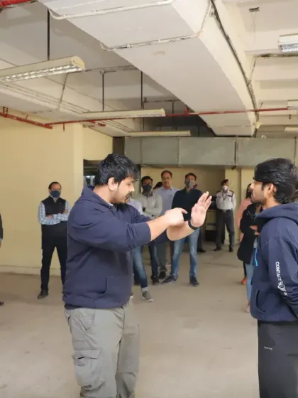 I provide corporate self-defense workshops to equip employees with the confidence and skills to stay safe. Here, I am demonstrating a basic defensive stance and block during a session.