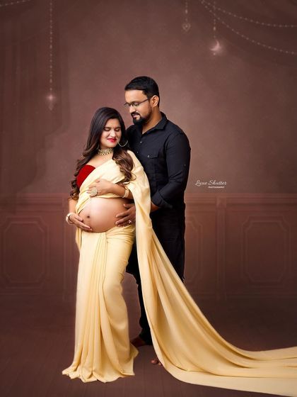 A full-view of the elegant cream-colored saree, highlighting its beautiful drape and flow. The couple's pose is both classic and intimate.