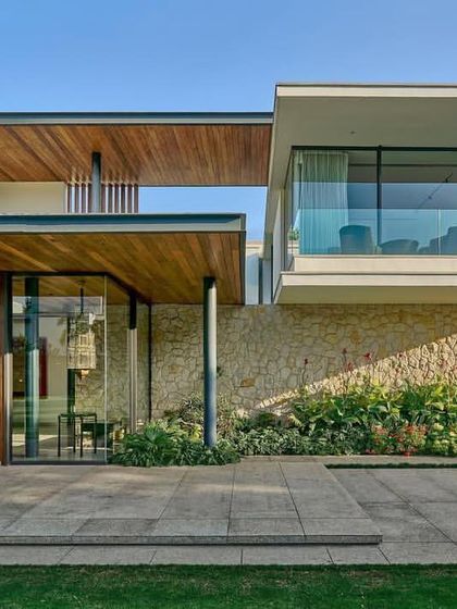 The 'Patio House' by DADA Partners is designed around a mature ficus tree, with expansive overhangs and glass walls that blur the line between inside and out.